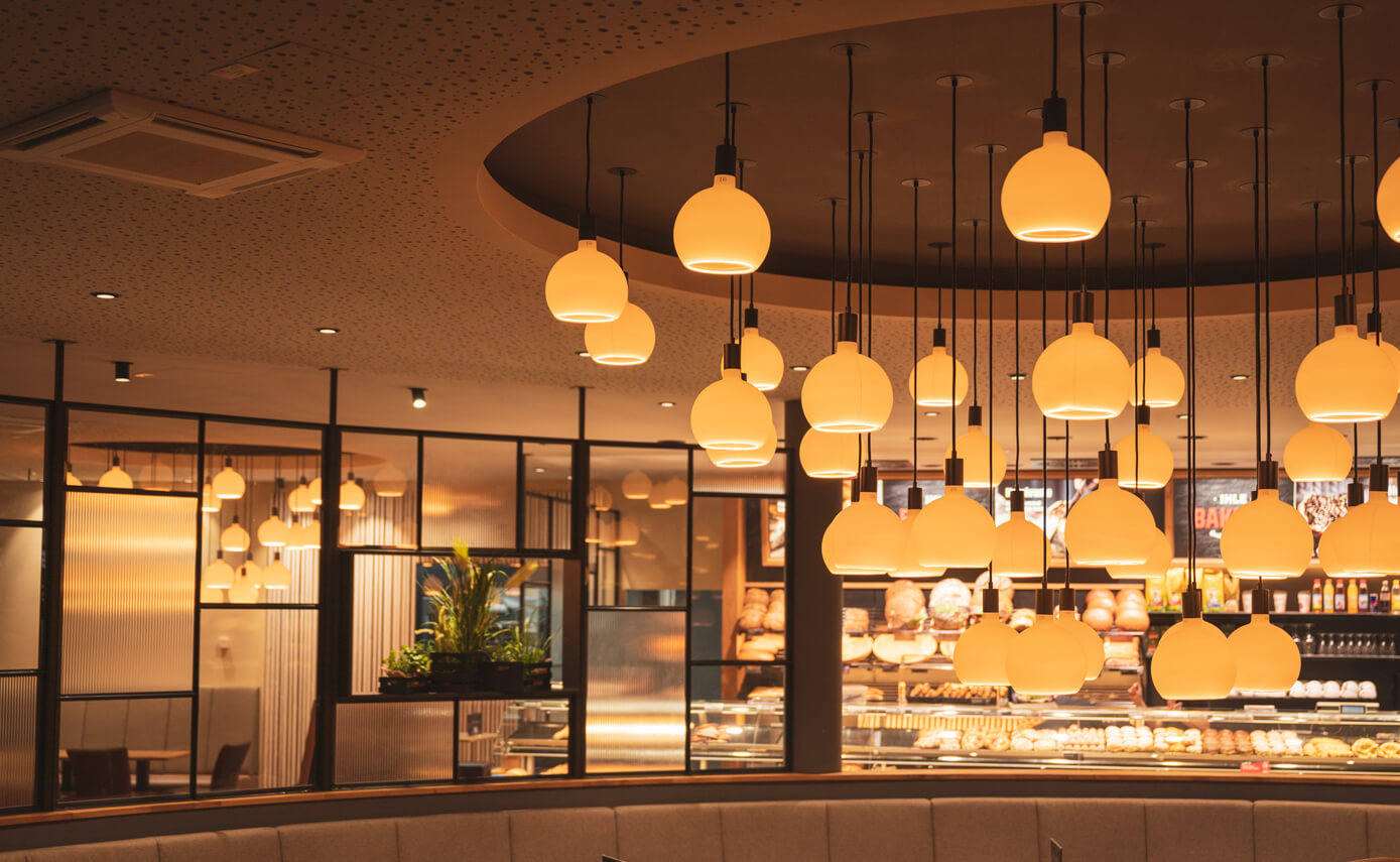 Reference image from lighting designer Maximales Licht: Bakers bakery, featuring numerous matt floating light fittings