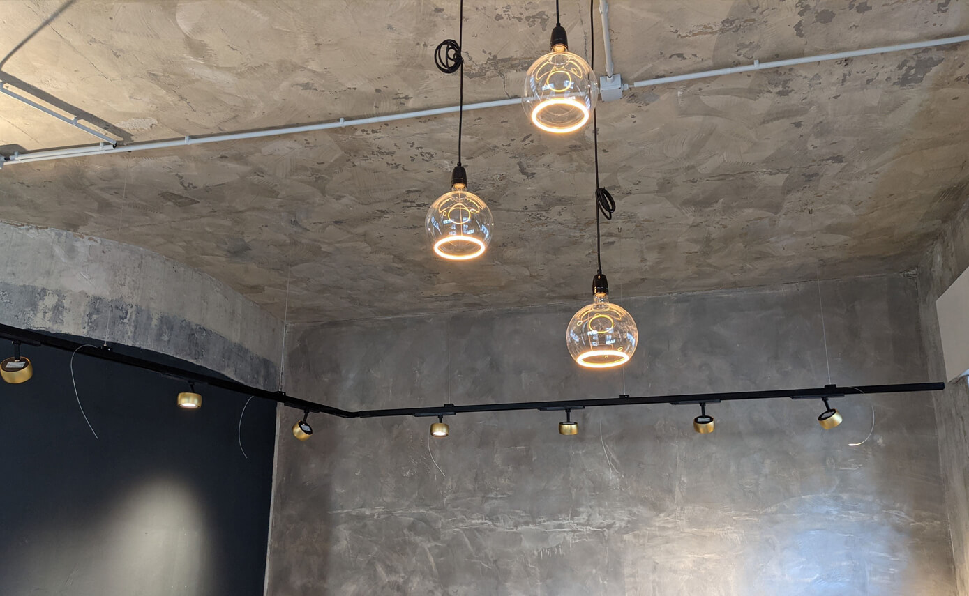 Reference image from Scola Raumkonzepte in Andernach: an exposed concrete wall with floating light fittings