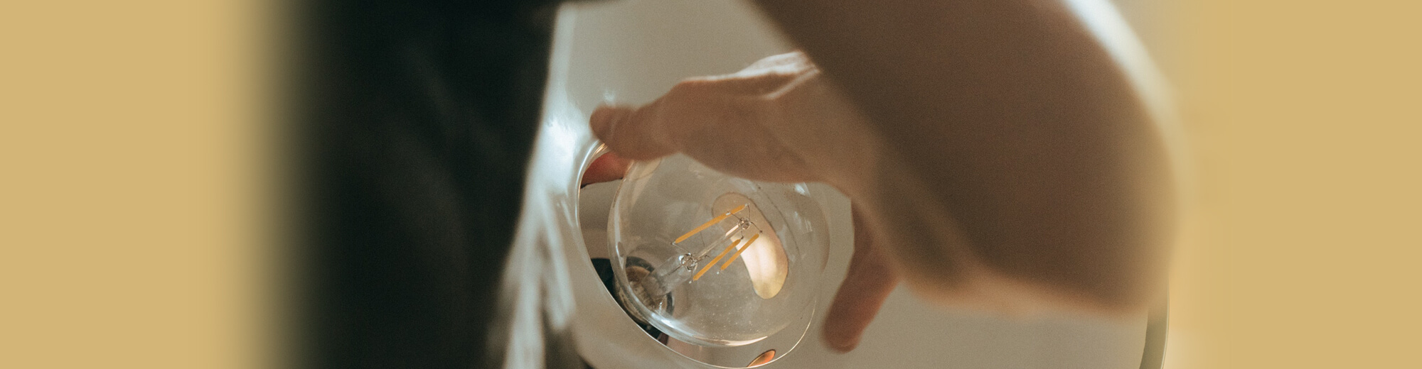 Image for the ‘Accessories’ category, showing a hand screwing a light bulb into a lamp