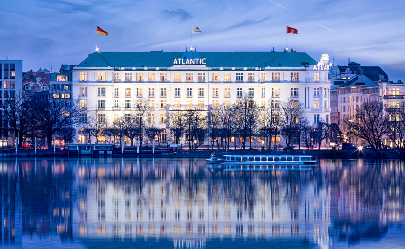 Reference image of the Hotel Atlantic in Hamburg, exterior view of the hotel with reflections in the lake