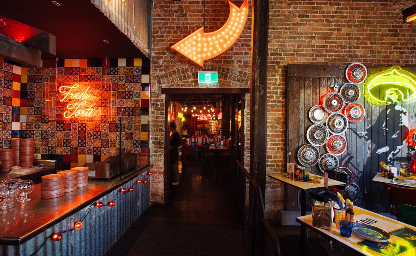 Reference image of the El Camino restaurant in Australia, featuring numerous light fittings and neon signs inside