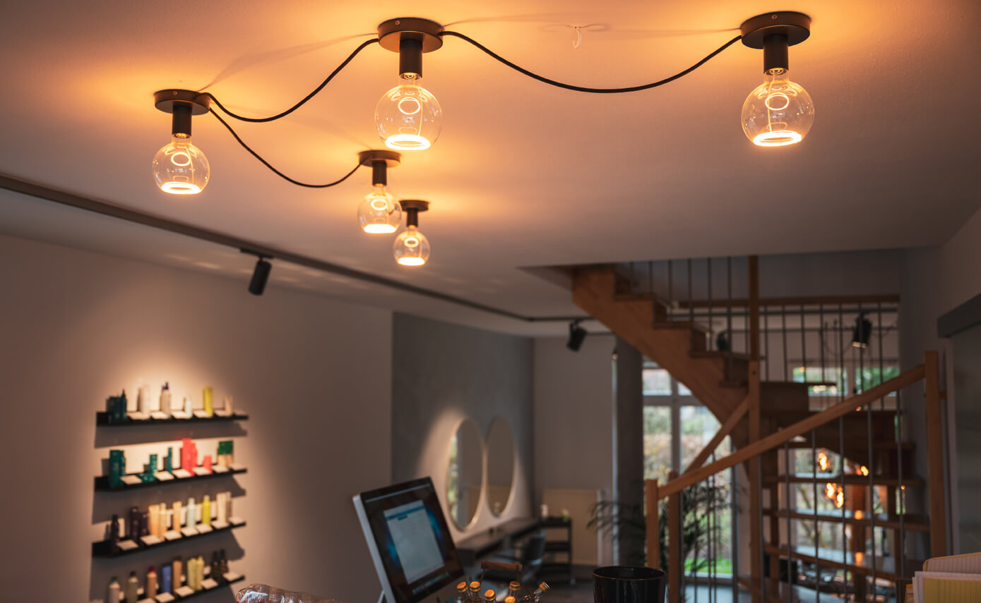 Reference image from lighting designer Maximales Licht: beauty salon with clear floating light fittings mounted directly on the ceiling