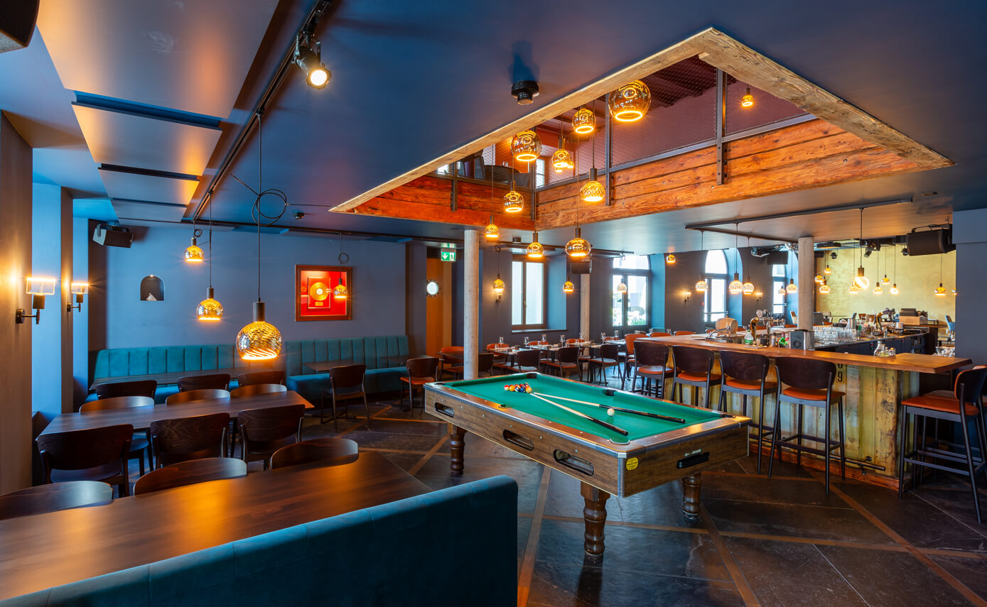 Reference image of the Goldener Anker restaurant in Interlaken, pool table with a gallery and numerous floating light fittings