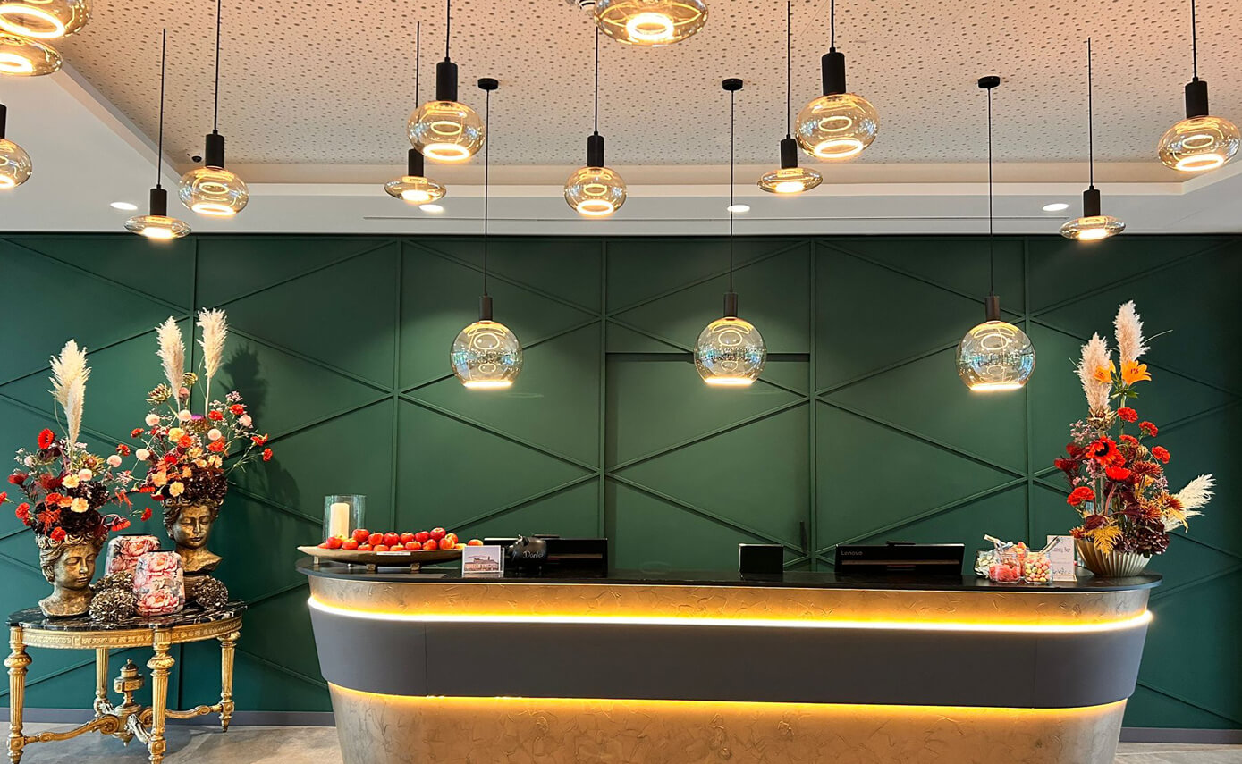 Reference image of the Karlshotel in Sigmaringen, reception desk featuring a variety of floating light fittings