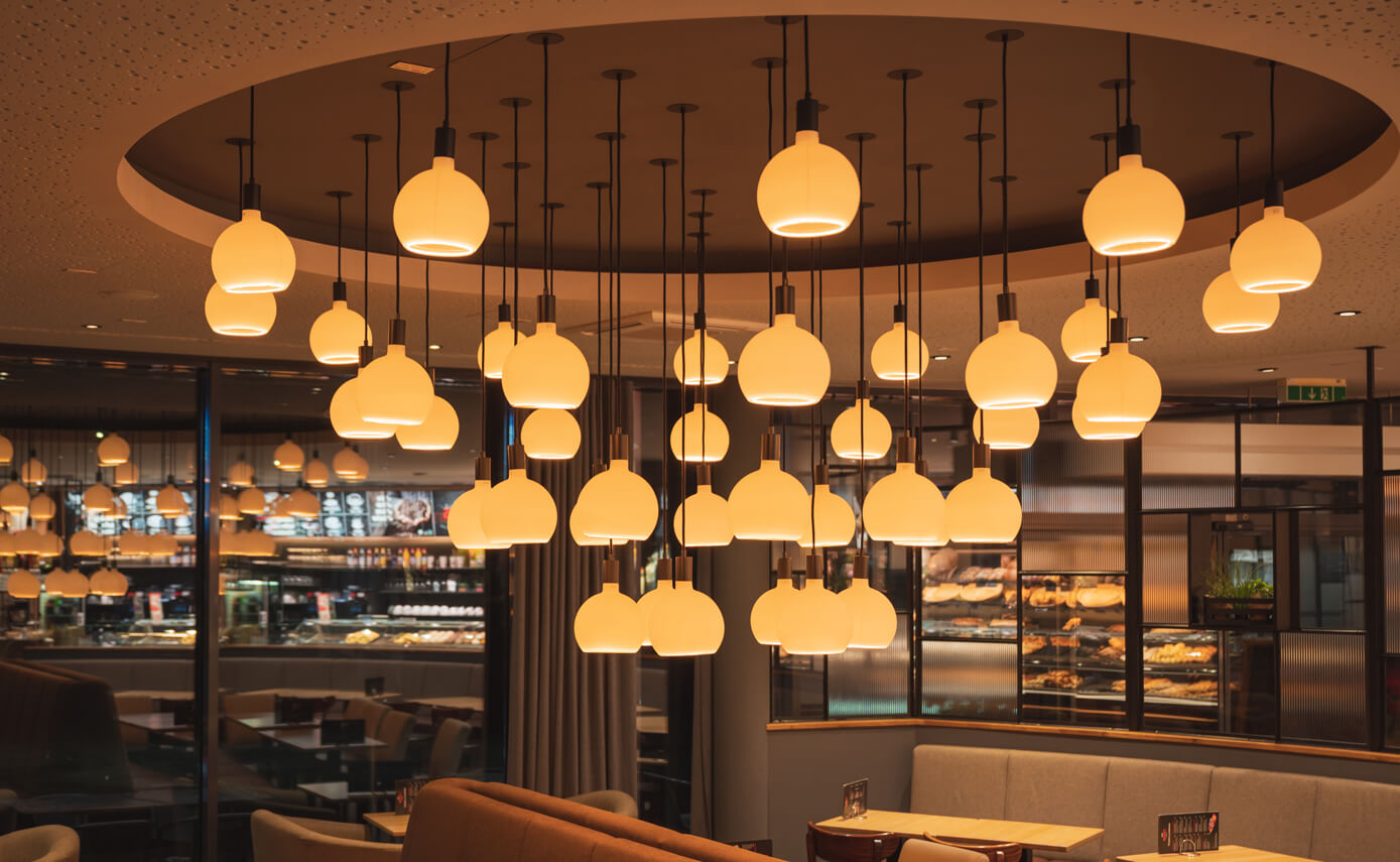 Reference image from lighting designer Maximales Licht: Bakers bakery, featuring numerous matt floating light fittings